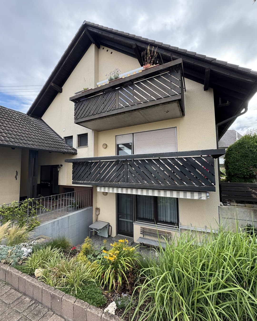 Wohnhaus in Oberschwaben vor der Fassadensanierung — verwitterte Putzfassade mit Balkonen
